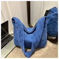Detalle del bolso tote de pana azul que muestra la textura de pana sobre una alfombra beige - Azul