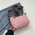 Rosa gesteppte Tragetasche mit blauem geometrischem Gurt auf Denim-Hintergrund - Rosa