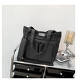 Detailansicht der schwarzen Nylon-Einkaufstasche mit Vordertaschen und Modelabel - Schwarz