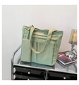 Detail einer hellgrünen Nylon-Einkaufstasche mit Vordertaschen und Mode-Lederetikett - Grün