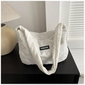 Détail de la texture d'un sac cabas rembourré blanc avec écusson de mode minimaliste - Blanc