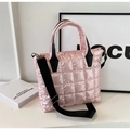 Detailed close-up of pink quilted puffer tote bag with black handles and shoulder strap - Pink