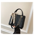 Detail of black quilted leather handbag featuring elegant silk scarf and gold chain - Black