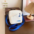 Sac bandoulière minimaliste en toile blanche avec étiquette mode bleue et sangle - Bleu