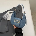 Minimalist blue denim crescent bag with golden buckle shown in a lifestyle urban setting - Light Blue