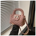 Detail van roze gewatteerde handtas met zilveren strik en elegant hard handvat - Roze