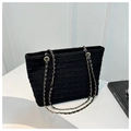 Nahaufnahme der schwarzen Tweed-Tasche mit goldenen Kettenriemen auf hellem Hintergrund - Schwarz
