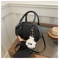 Dettaglio borsa boston in pelle nera con ciondolo peluche mostro bianco e doppi manici - nero con ciondolo