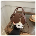 Borsa a tracolla ovale marrone con ciondolo mostro di peluche bianco su un tavolo - Marrone con ciondolo