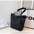 Detail of black canvas tote bag showing front zipper pocket and Fashion label branding - Black
