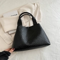 Bolso tote negro tejido a mano con asa de nudo sobre fondo minimalista y elegante - Negro