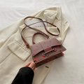 Bruine crossbodytas met aardbeienprint van litchi leer op een beige blazer - Oudroze
