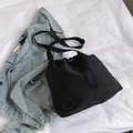 Sac seau noir minimaliste avec cordon et bandoulière sur veste en jean bleu clair - Noir