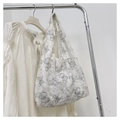Gros plan détaillé de la broderie papillon délicate sur un sac cabas en maille blanche - Gris