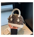 Detail of leopard print shell bag with white leather trim and golden metal hardware - White