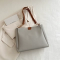 Elegante bolso tote de cuero gris con correas marrones y detalles de cadena dorada - Gris
