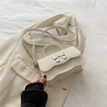 Creamy white crossbody bag with pearl handle and silver bow accent for women - White