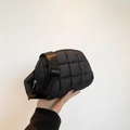 Sac bandoulière matelassé noir tendance avec bandoulière réglable tenu à la main - Noir