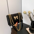 Schwarze gesteppte Schultertasche mit goldener Schleife und goldener Kette - Schwarz