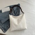 Chic off-white hobo bag with vintage wooden bead handle and textured faux leather finish - White