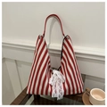 Detail of red and white striped canvas tote bag featuring a white lace bow and metal ring - Red