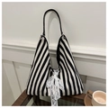 Close-up of black and white striped canvas tote with lace bow and woven handles - Black