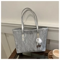 Close-up van metallic zilveren shopper met kreuktextuur en schattige pluche hanger - Met Hanger / Zilver