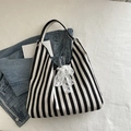 Chic black and white striped tote bag with a white lace bow detail and wide shoulder strap - Black