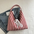 Red and white striped tote bag with white lace bow detail and simple fabric handles - Red