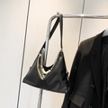 Black leather hobo bag with silver chains and pearls hanging on a silver hanger - Black
