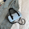 Mini sac cylindrique bleu clair avec bandoulière à pois sur une veste en jean - Bleu