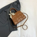 Sac à main matelassé marron avec foulard en soie sur fond de blazer gris - Marron