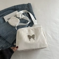 White large shoulder bag with butterfly detail and round coin purse on denim background - Off White