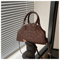 Close-up of brown spiderweb embroidered handbag with unique wave-edge design - Coffee