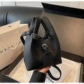 Détail du sac seau noir en cuir grainé litchi avec ferrures argentées et bandoulière - Noir