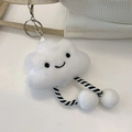 White plush cloud charm with smiley face and striped legs hanging on a woven shoulder bag - Individual Pendant (Cloud Shape)