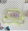 Detail of mint green crossbody bag featuring a clear window display with cute bunny badges - With Badge / Green