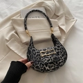Borsa a mezzaluna leopardata con fibbia dorata ondulata su sfondo beige - Nero