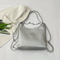 Zilveren hobo-tas met gekreukte textuur en metallic M-logo op een stijlvolle achtergrond - Zilver