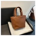 Détail du sac fourre-tout caramel sur doublure en soie dans un coffret cadeau noir - Marron
