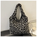 Gros plan du sac cabas en fausse fourrure léopard sur un canapé en cuir noir style de vie - Noir