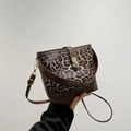 Fashionable leopard print bucket bag with brown leather trim and golden twist lock - Brown