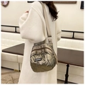 Quilted shell bag in champagne metallic finish shown on shoulder in a cafe setting - Champagne Gold