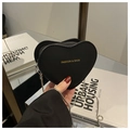 Détail du mini sac en cuir noir en forme de cœur avec lettrage doré et chaîne argentée - Noir