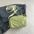 Minimalistische mintgrüne Umhängetasche mit vertikaler Naht auf blauem Denim-Hintergrund - Grün