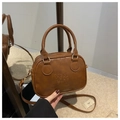 Close-up of vintage brown leather handbag featuring lucky LHCO smu embossed lettering - Brown