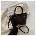 Detail of dark brown glossy bucket bag with gold hardware on beige suit jacket - Coffee Without Pendant