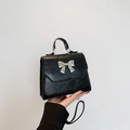 Borsa in ecopelle nera lucida con fiocco in metallo argento e tracolla sottile nera - Nero