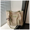 Detail of woven straw tote bag with light green leather accents and gold hardware - Green