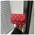 Detailed view of a small red handbag with white polka dots held by hand - Red